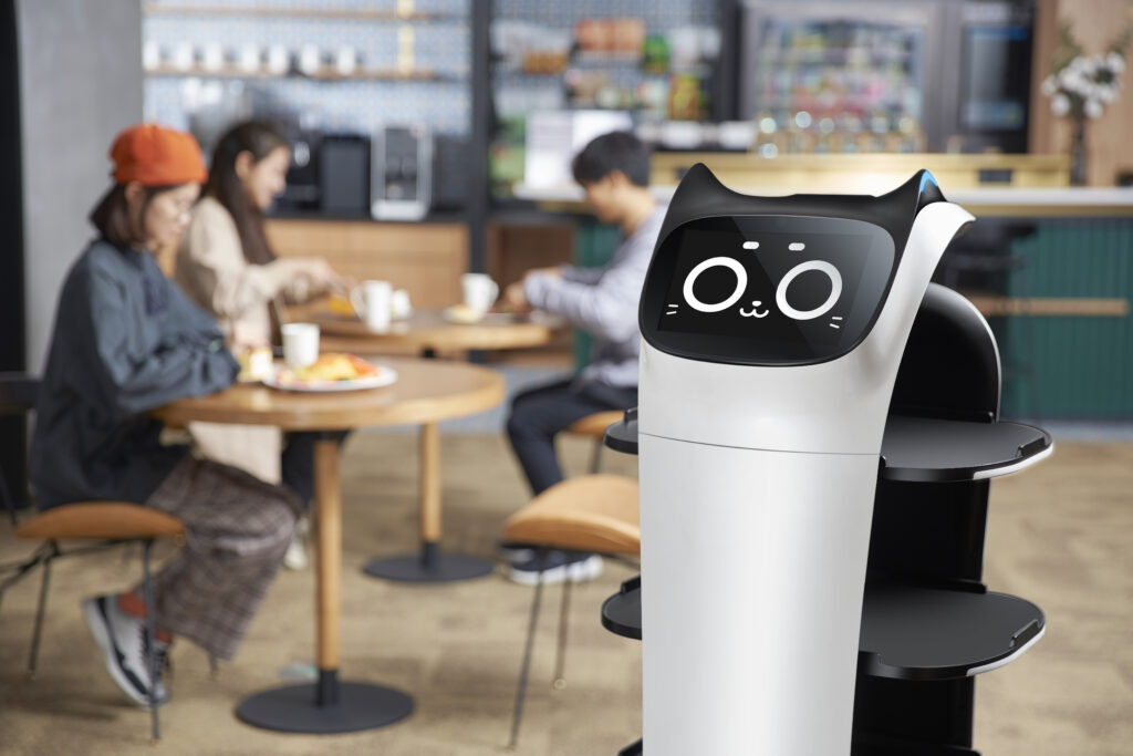 BellaBot Servierroboter in der Kantine mit Menschen im Hintergrund
